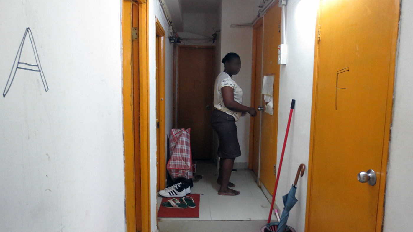 An African refugee enters a subdivided unit in Hung Hom, unrelated to this blog